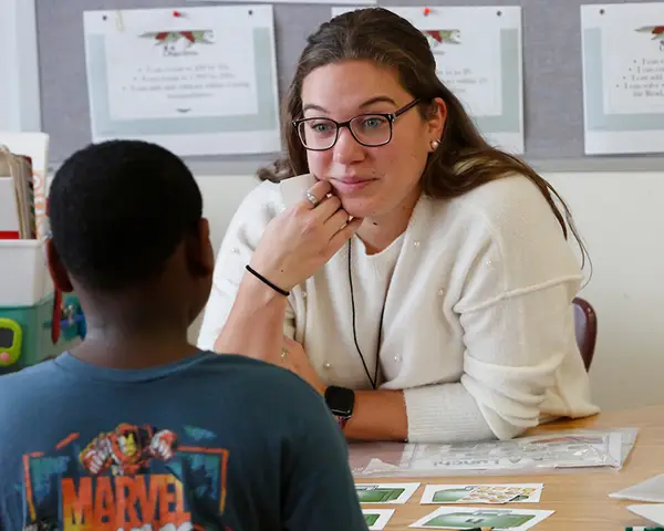 teacher listens to a young student